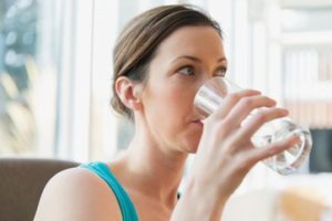 Pretty woman drinking glass of water.